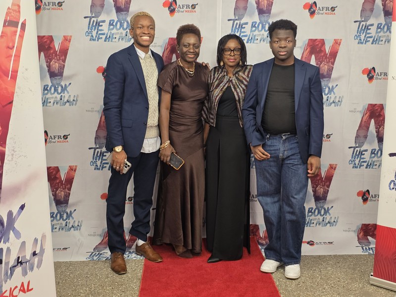 A family of four posing together at the Chicago private screening step-and-repeat